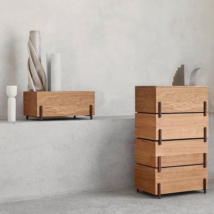 two wooden boxes sitting next to each other on top of a cement floor in front of a white wall