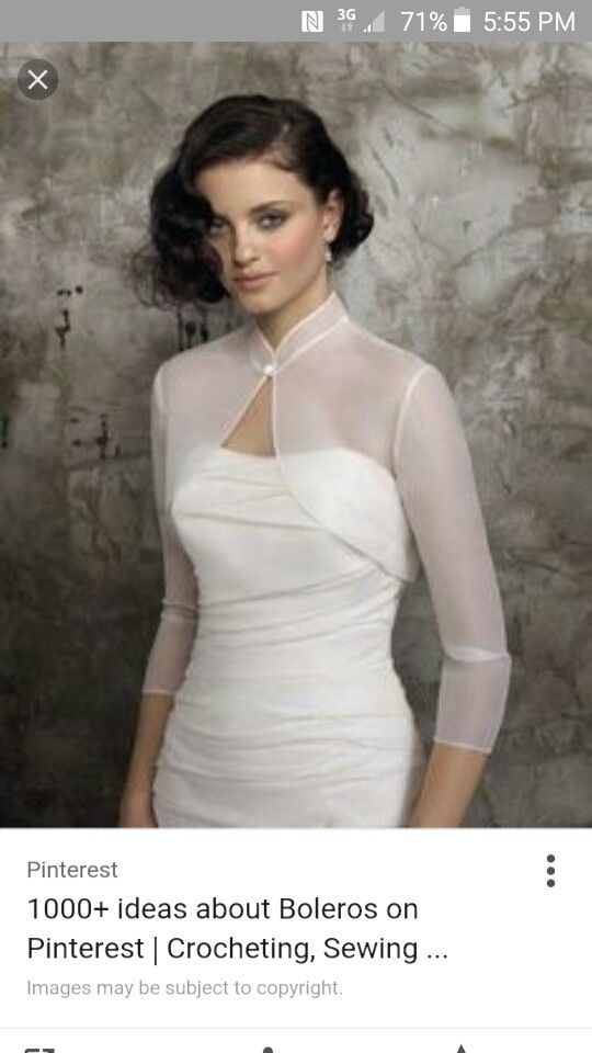 a woman wearing a white dress with sheer sleeves