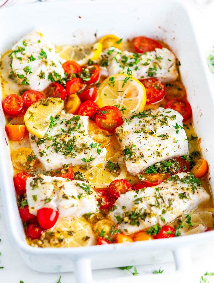 fish with tomatoes and lemons in a white casserole