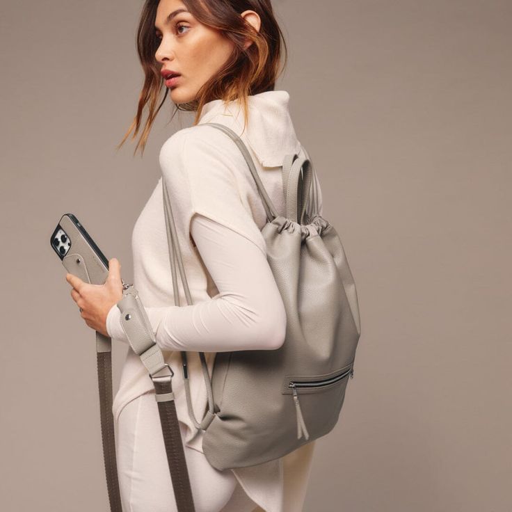 Elevate your daily routine with the Bandolier Drawstring Backpack - a perfect balance of luxury and practicality. The backpack is crafted from the finest, durable pebble leather and features an adjustable leather drawstring opening that cinches to close and open the bag. The classic and timeless silhouette of the backpack is designed to fit a 13-inch laptop, making it perfect for everyday use. Daily Essentials, Embossed Logo, Daily Routine, Online Purchase, Pebbled Leather, Smooth Leather, Drawstring Backpack, Leather Backpack, Zip Pockets