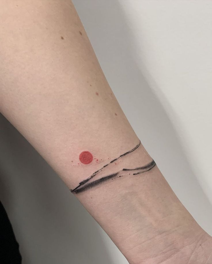 a woman's arm with a small red dot on the left side of her wrist