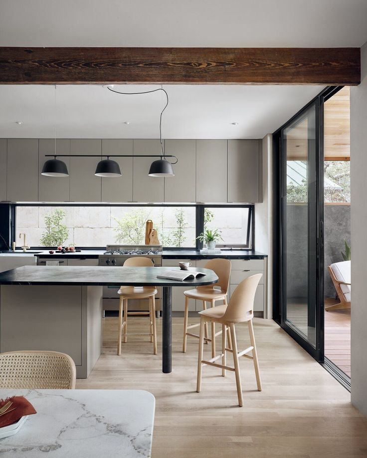 an open kitchen and dining area with wooden flooring, white countertops and gray cabinets