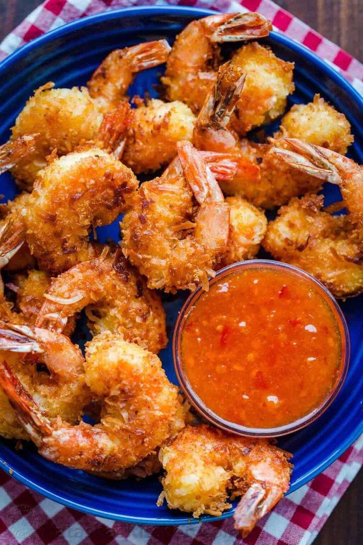 a blue plate topped with shrimp and dipping sauce