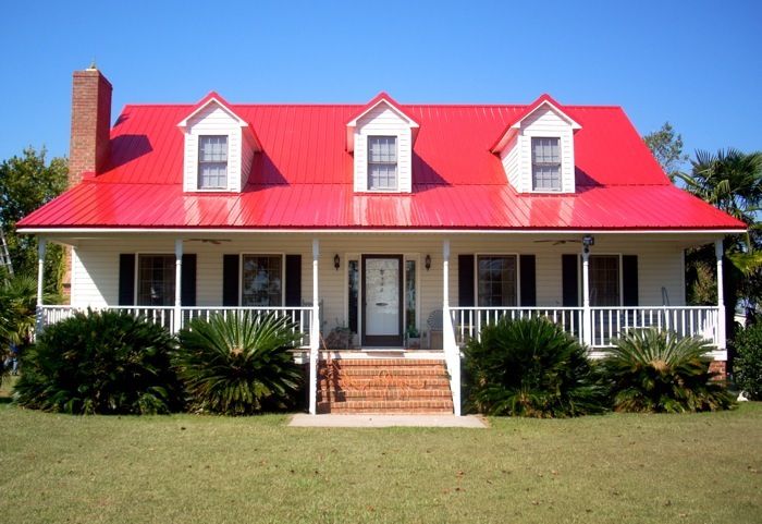 a white house with red roof and porch