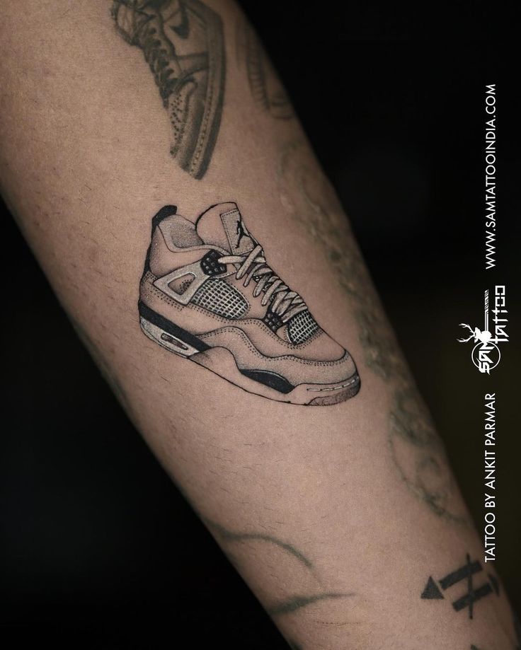 a person with a tattoo on their arm has a sneaker tattooed on his leg