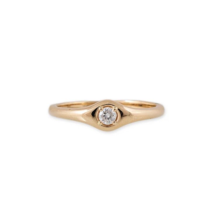 a gold ring with a white diamond on the center, and a small round stone in the middle