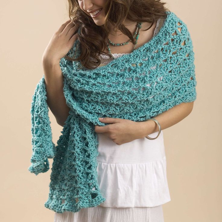 a woman wearing a blue crocheted shawl