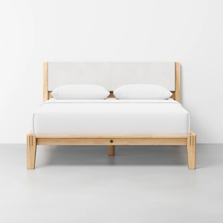 a bed with white linen and wooden frame