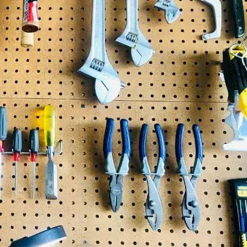 there are many tools hanging on the pegboard