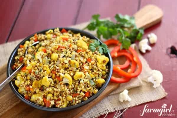 a bowl filled with food sitting on top of a wooden cutting board next to vegetables