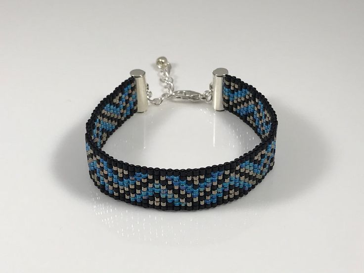 a blue and black bracelet on a white surface