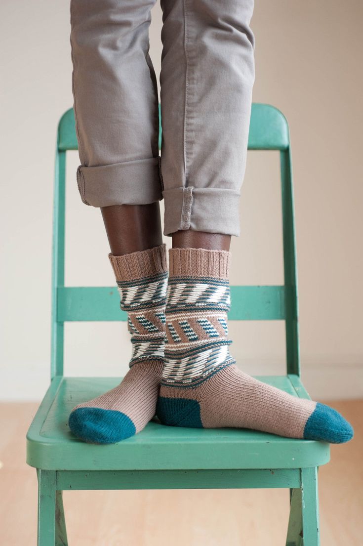 a person standing on top of a green chair wearing socks and socks with blue feet