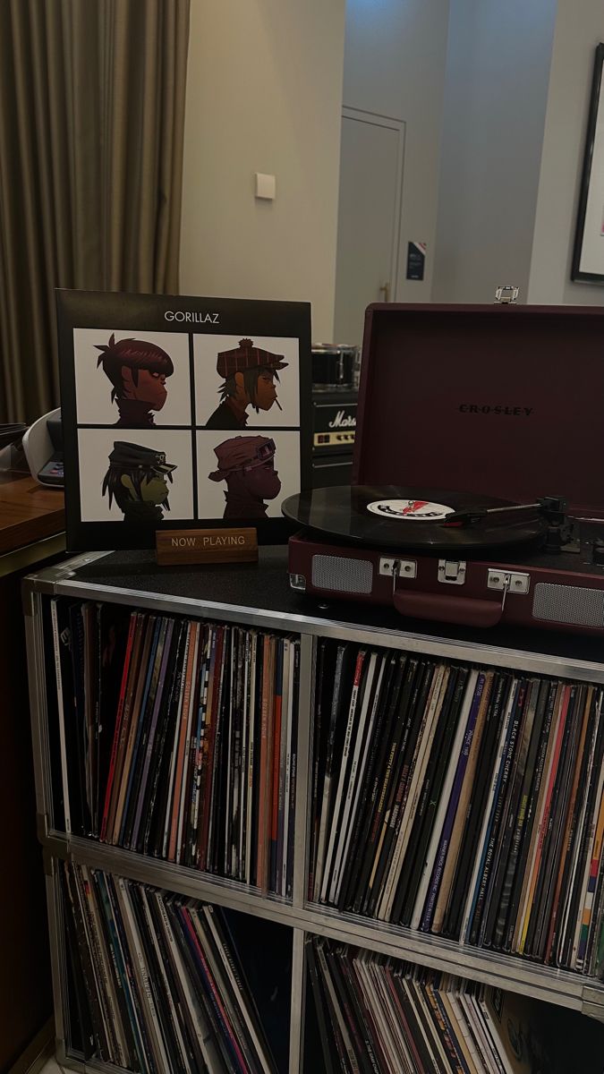 an old record player sitting on top of a shelf next to a cd case filled with vinyl records