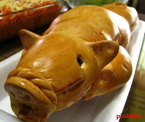 a close up of a stuffed animal on a plate with other food items in the background