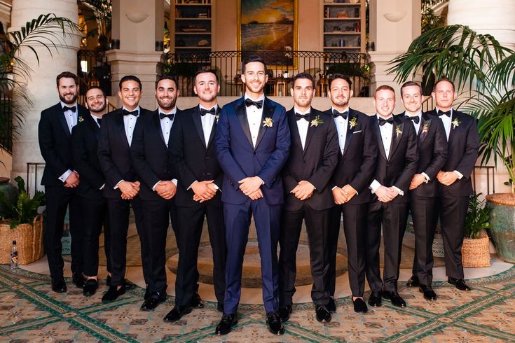 a group of men standing next to each other in tuxedos