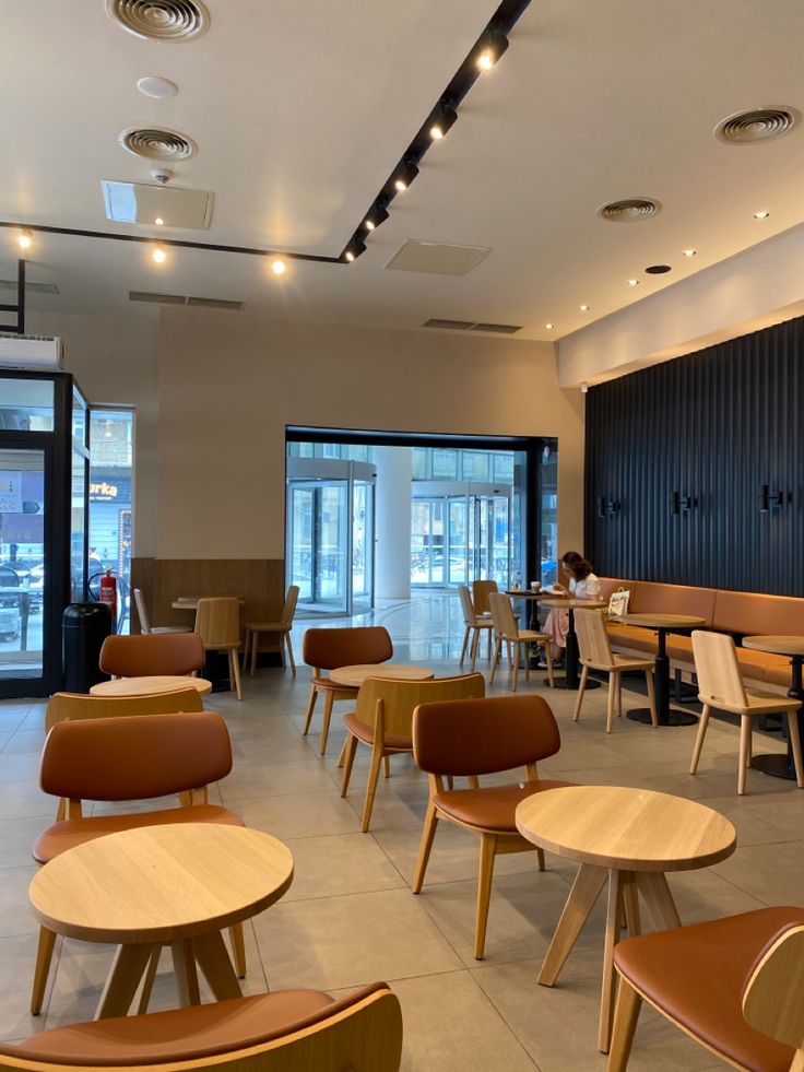 an empty restaurant with wooden tables and chairs