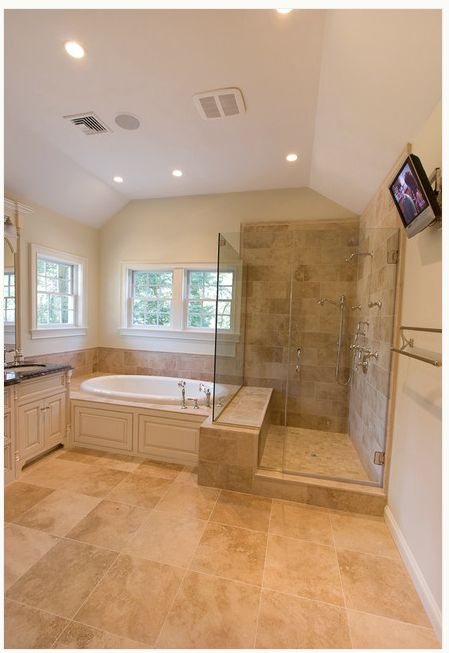 a large bathroom with a walk in shower next to a tub