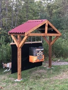 a small wooden shelter with a red roof