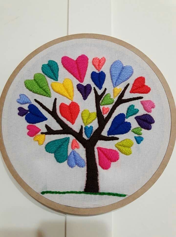 a colorful tree with hearts on it in a white hoop hanging from the side of a wall