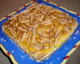 a blue and yellow plate topped with a casserole covered in toppings