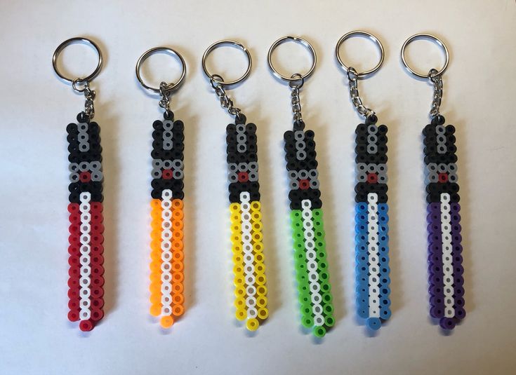 six lego keychains with different colors and designs on them, all in the same row