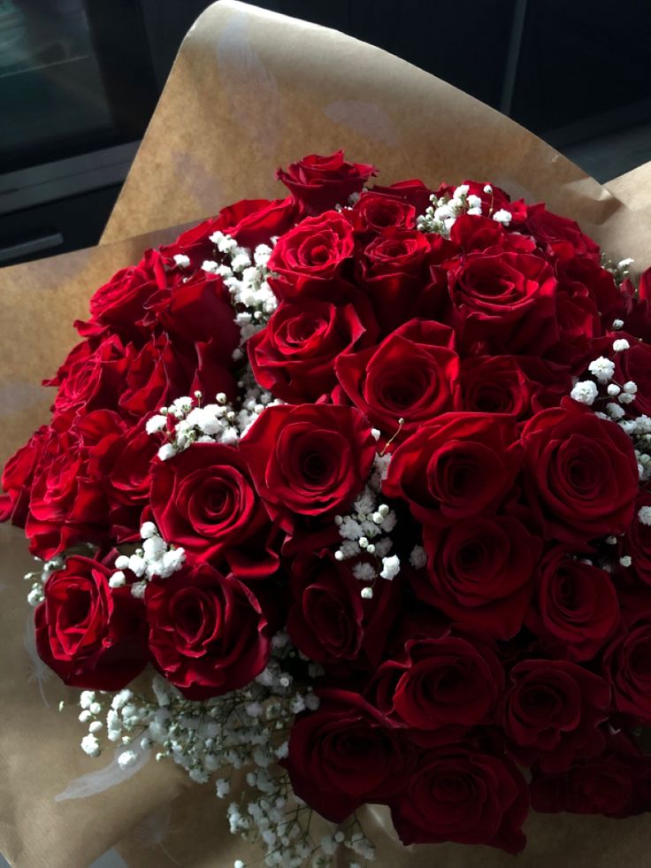 a bouquet of red roses with baby's breath