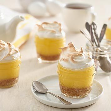 small desserts with whipped cream and spoons on a table