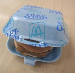 a plastic container with a hamburger in it