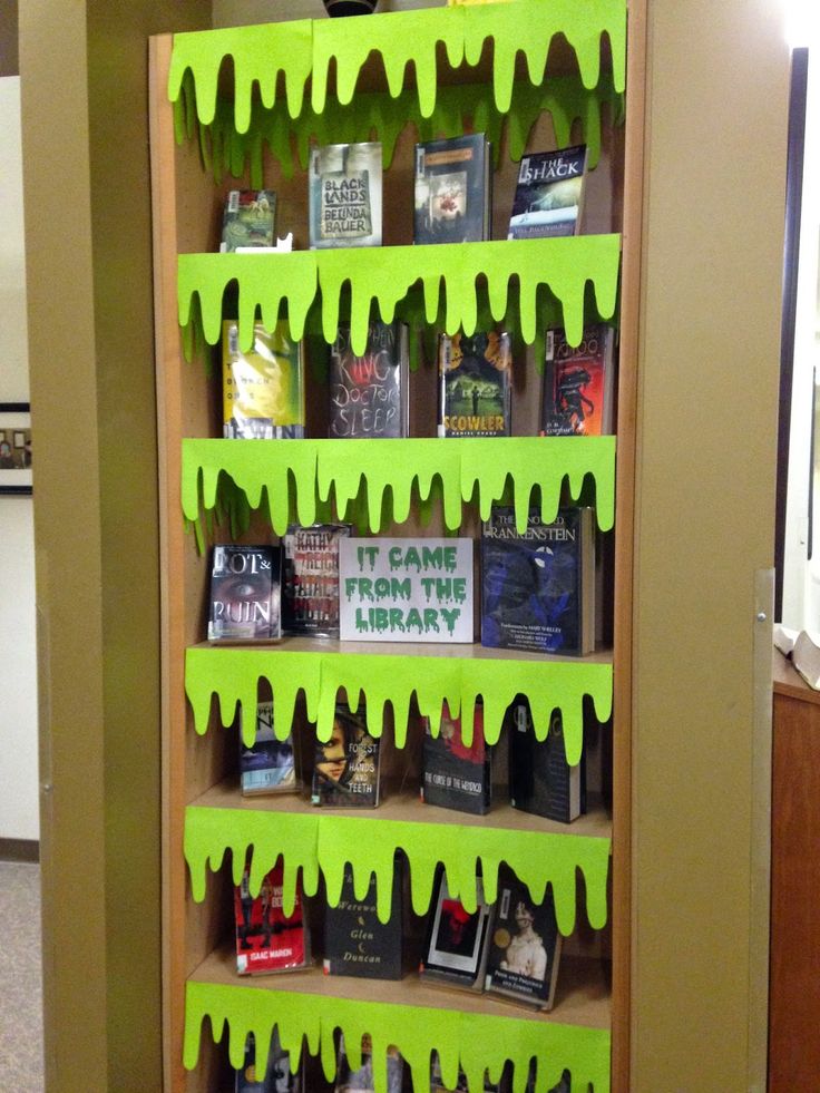 a book shelf with green paint dripping down the sides and books on it's shelves