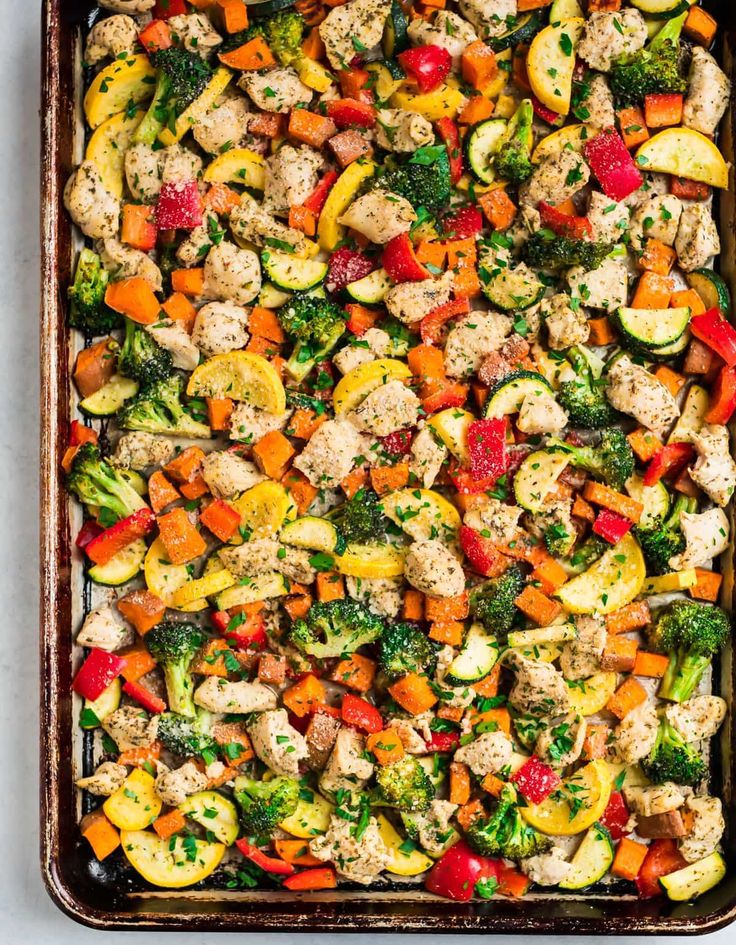 a casserole dish with chicken, broccoli, and zucchini