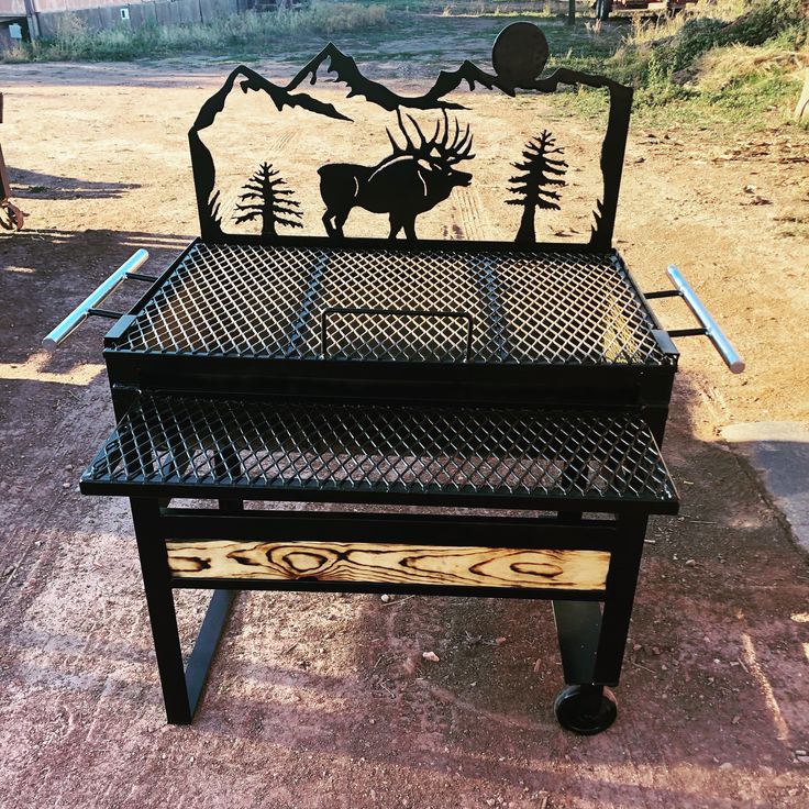 an outdoor grill made out of metal and wood with a moose design on the top