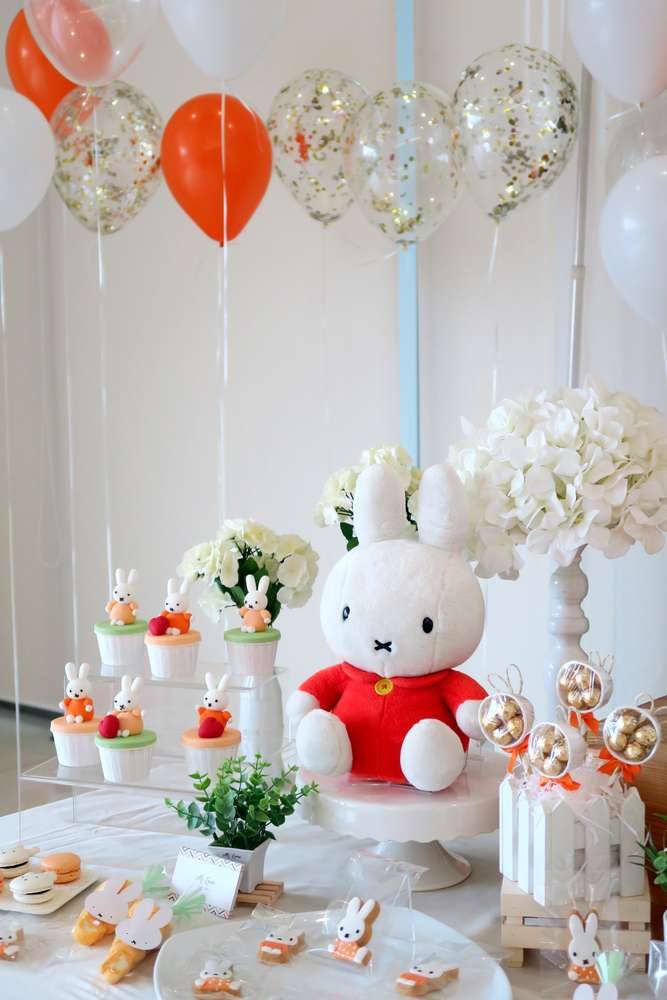 a white table topped with lots of food and balloons