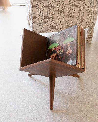 an open magazine rack on the floor in a living room