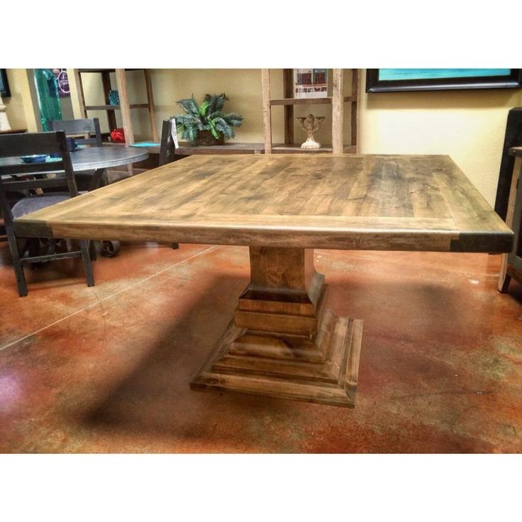 a wooden table sitting in the middle of a room with chairs and tables around it