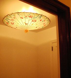 the reflection of a lamp in a mirror on a wall above a door and floor