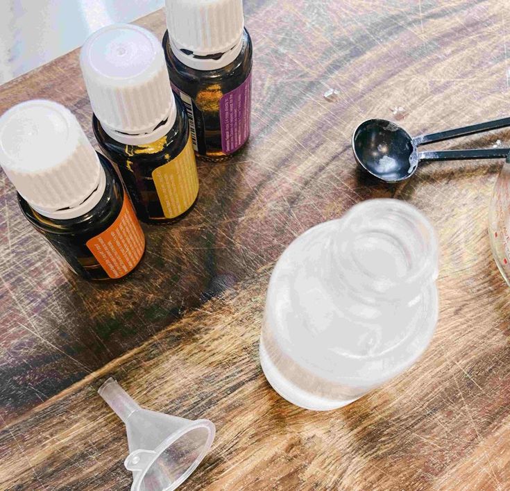 an assortment of essential oils and spoons on a wooden table