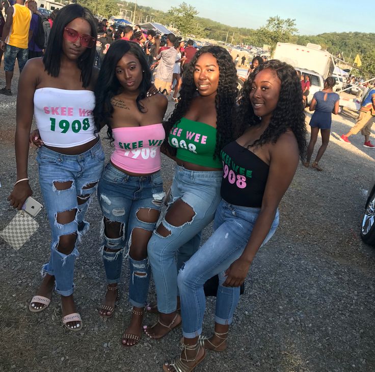 three women standing next to each other in ripped jeans