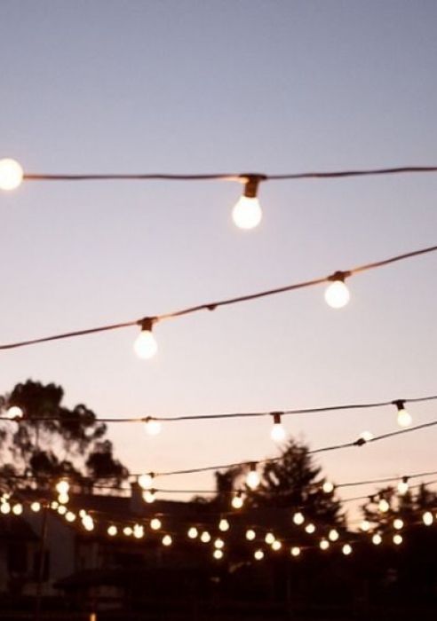 string lights are hanging from the ceiling outside