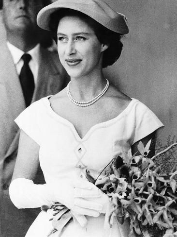 an old black and white photo of a woman in a wedding dress holding a bouquet