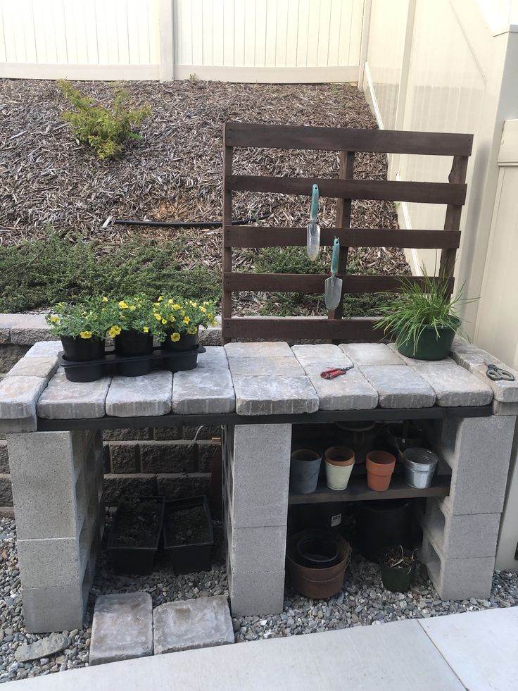 an outdoor garden with potted plants and gardening tools