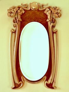 an ornate mirror mounted to the side of a wall