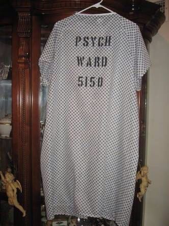 a t - shirt that says, psychic ward died on it hanging in front of a wooden cabinet