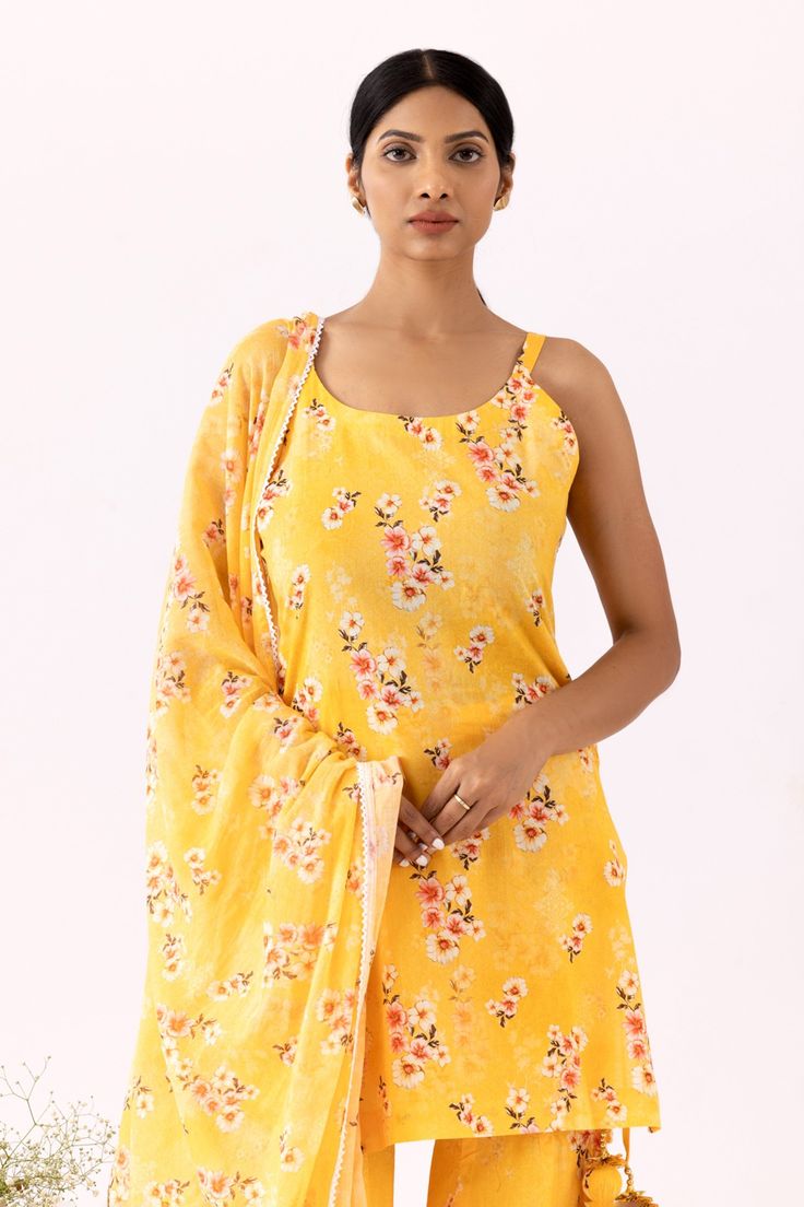 Mustard yellow sleeveless kurta with all over floral bloom print. Paired with coordinating floral print gharara and dupatta.
Components: 3
Pattern: Print
Type Of Work: Floral Bloom
Neckline: Scoop Neck
Sleeve Type: Sleeveless
Fabric: Cotton Cambric
Color: Yellow
Other Details: 
Lace trimmings
Floral print dupatta
Occasion: Mehendi and Haldi - Aza Fashions Yellow Georgette Bollywood Sharara, Bollywood Style Yellow Georgette Sharara, Yellow Bollywood Georgette Sharara, Summer Sharara With Unstitched Blouse In Georgette, Yellow Georgette Lehenga With Straight Kurta, Yellow Georgette Sharara With Gota Work, Yellow Georgette Sharara With Sheer Dupatta, Yellow Georgette Sharara For Eid, Designer Yellow Lehenga With Dabka Embroidery