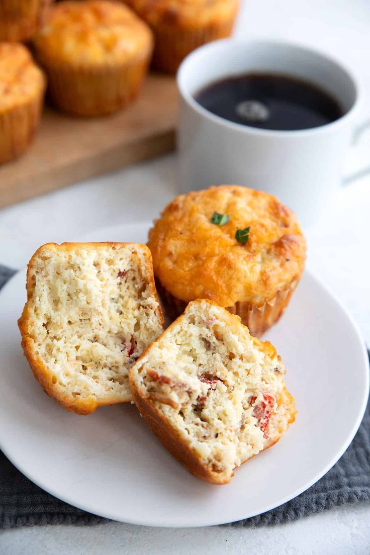 three muffins on a white plate with a cup of coffee in the background