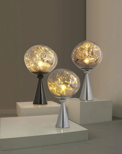 three glass globes with lights on them sitting on top of some white pedestals