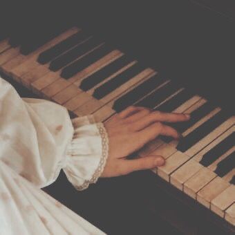 a person is playing the piano with their hand on it's keys and wearing a white dress