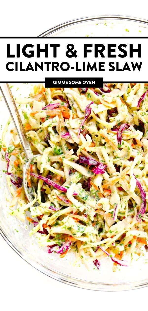 a glass bowl filled with coleslaw slaw and topped with two serving spoons