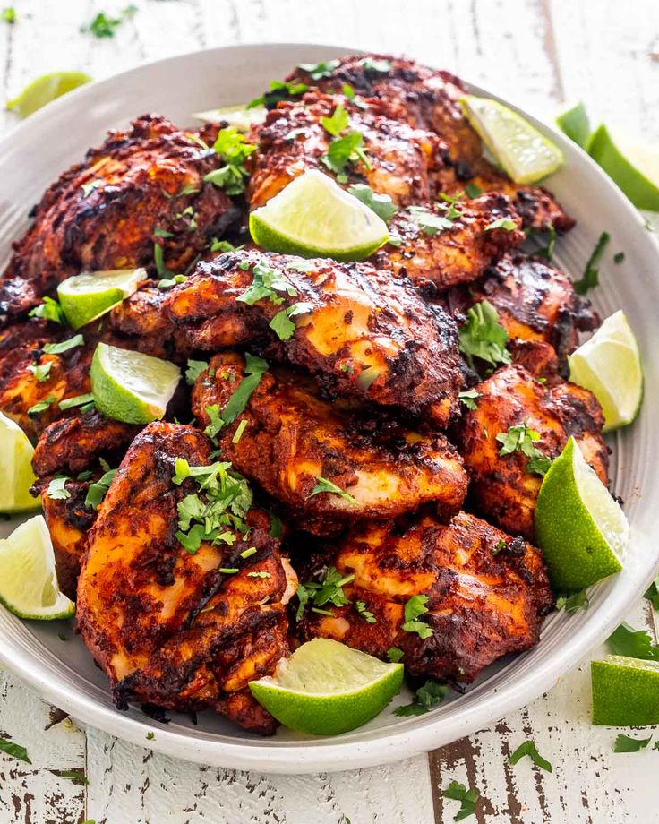 a white plate topped with chicken and limes