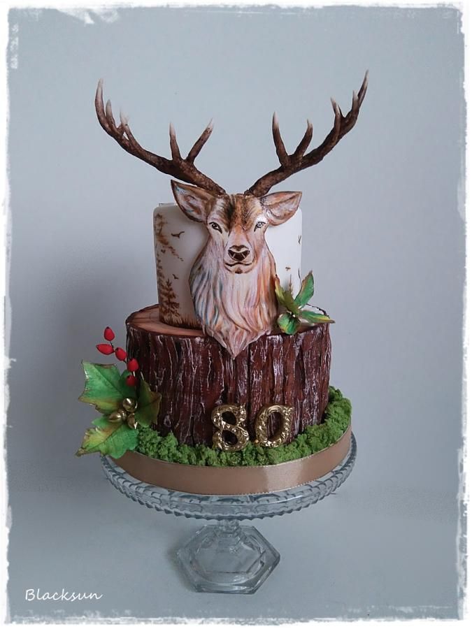 the cake is decorated with deer heads and greenery