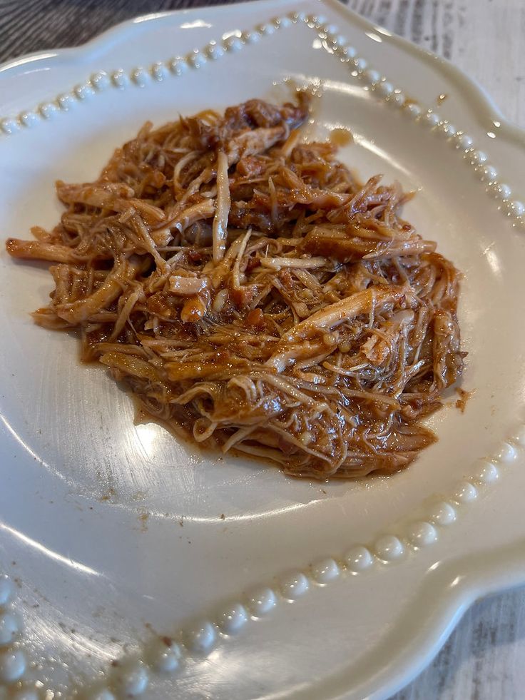 shredded meat sitting on top of a white plate